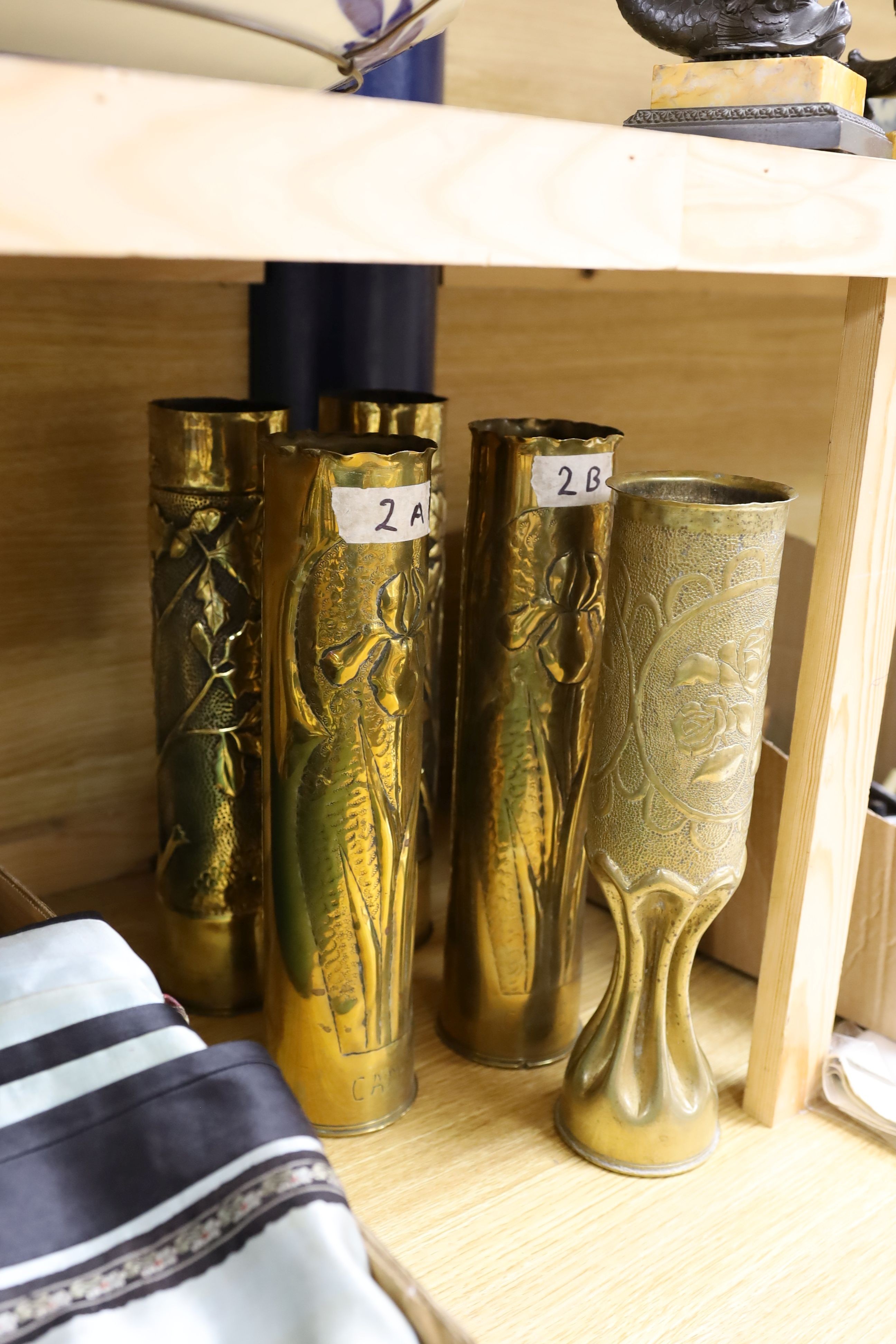 A collection of twelve WWI trench art shell casings, tallest 35 cms high.